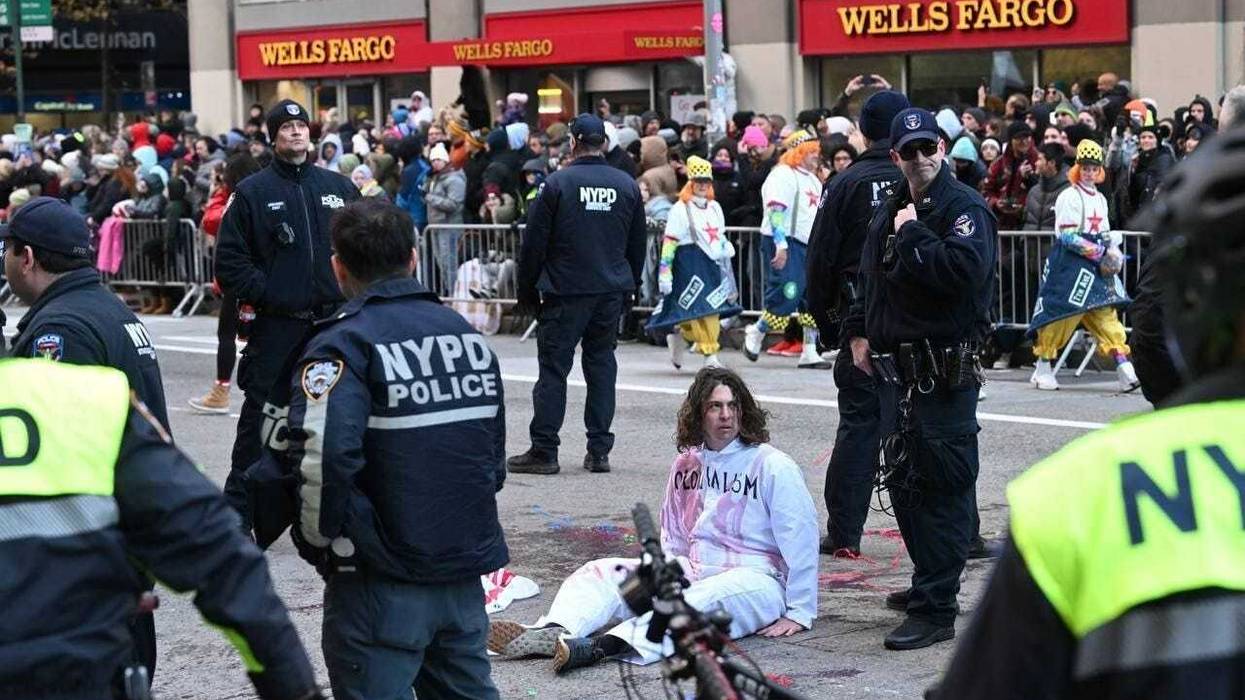 New York Police Department (NYPD) members intervene and take two pro-Palestinian protesters into custody, who entered the parade, during the traditional Thanksgiving Day parade in New York, United States on November 23, 2023.