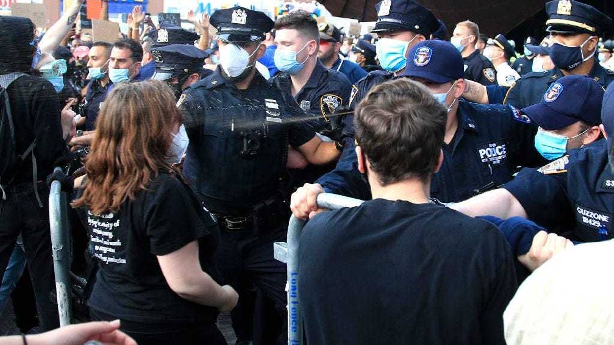 New York Police Department (NYPD) officers spray tear gas during a protest in response to the police killing George Floyd in front of Barclays Center on May 29, 2020 in the Brooklyn borough of New York City.