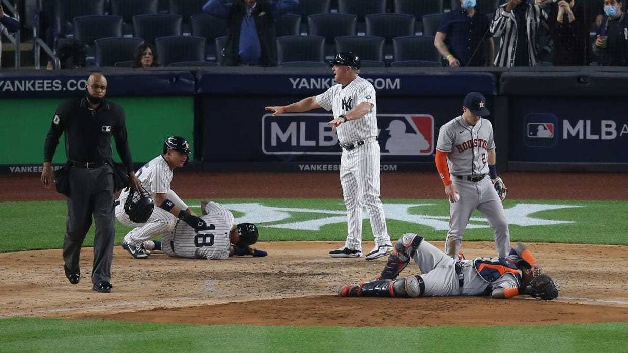 New York Yankees second baseman Rougned Odor (18) and Houston Astros catcher Martin Maldonado (15) react after colliding at home plate during the sixth inning at Yankee Stadium.