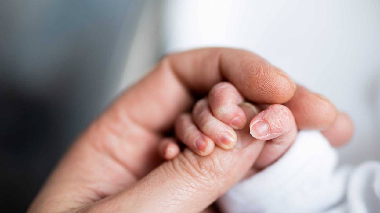Newborn holding mother's hand
