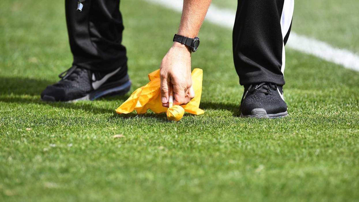 NFL referee picking up a penalty flag