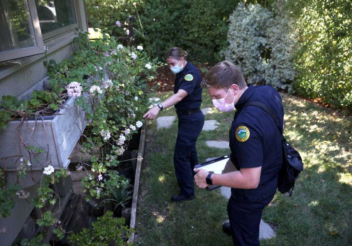Nicolas McNamara (R) and Kristi Cascio, (L) inspectors with the Marin Wildfire Prevention Authority, survey a property during a defensible space inspection on June 29, 2021 in Greenbrae, California. As the severe drought continues in California, the newly established Marin Wildfire Prevention Authority is conducting county-wide defensible space inspections to help educate homeowners in identifying potential fire hazards around their homes ahead of wildfire season. A total of 26 inspectors are going door-to-door and logging things of concern. (Photo by Justin Sullivan/Getty Images)