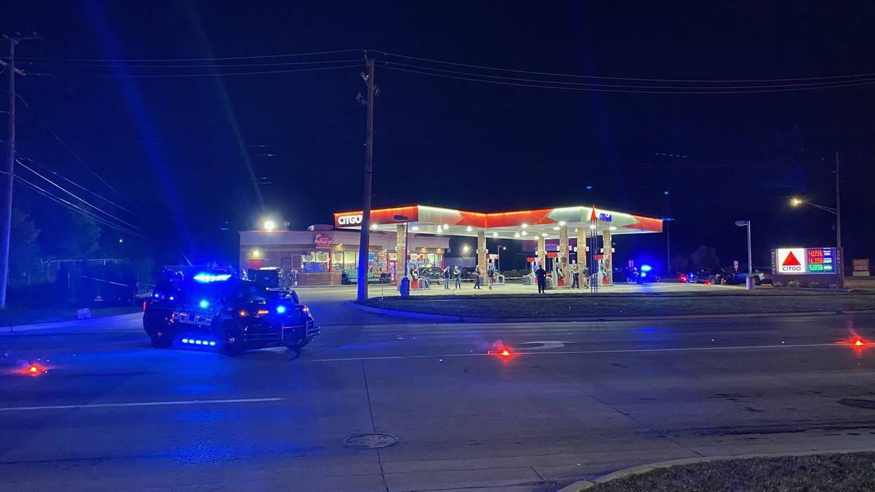 Night: Police vehicle with blue lights, red flares on road near Citgo gas station incident.