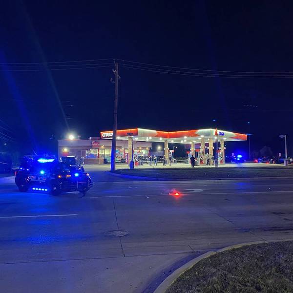 Night: Police vehicle with blue lights, red flares on road near Citgo gas station incident.