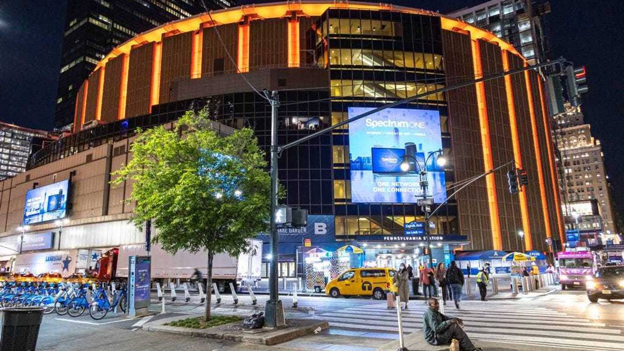 Night street view with illuminated buildings and lights of Madison Square Garden in Manhattan.
