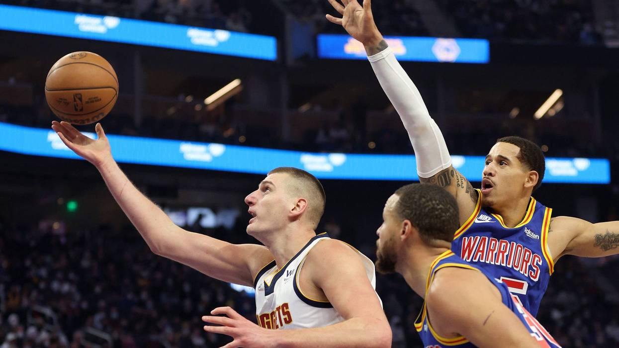 Nikola Jokic #15 of the Denver Nuggets goes up for a shot on Juan Toscano-Anderson #95 and Stephen Curry #30 of the Golden State Warriors at Chase Center on December 28, 2021 in San Francisco, California.