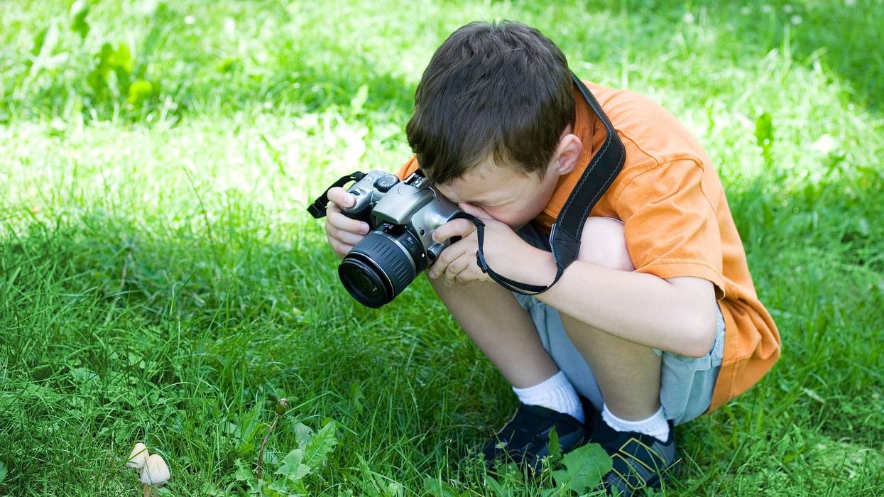 niño tomando fotos afuera