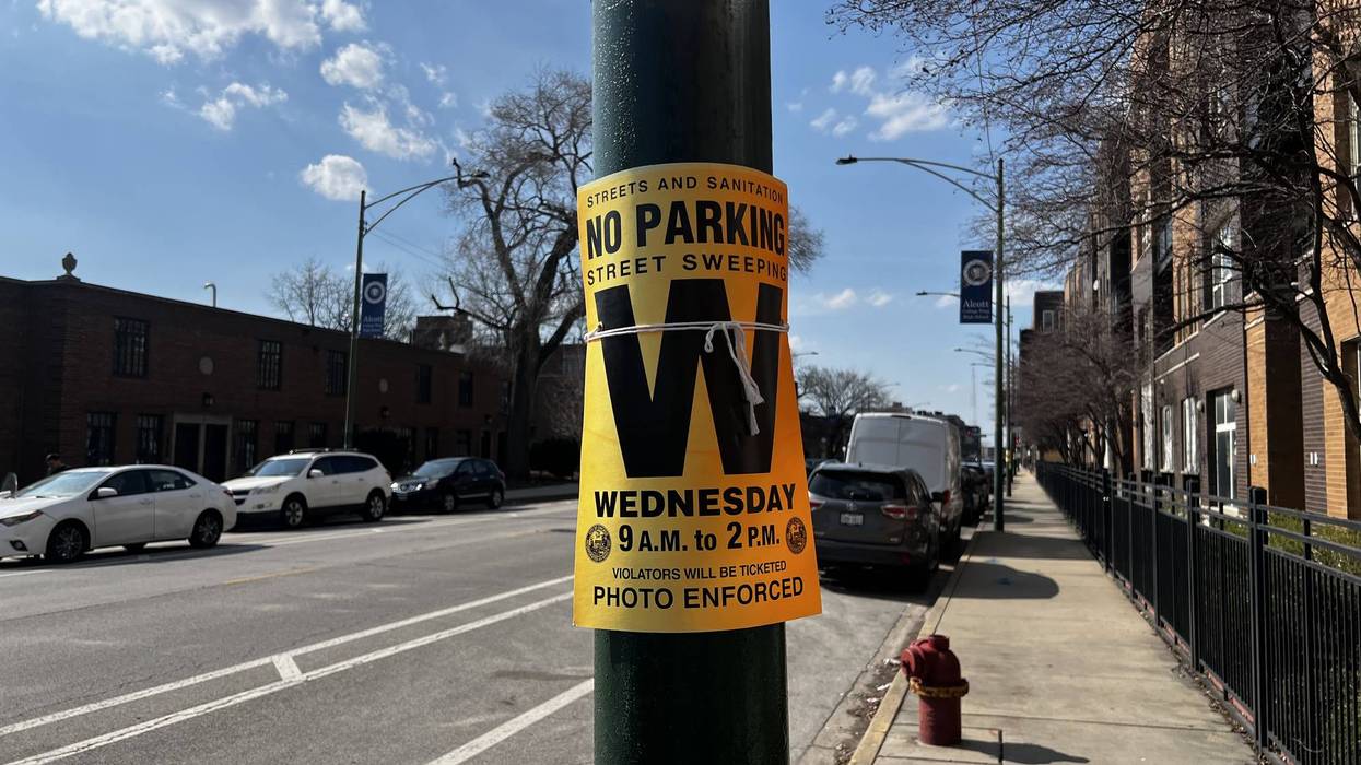 'No Parking Street Sweeping' sign for Wednesday 9 AM-2 PM on a sunny Chicago street.