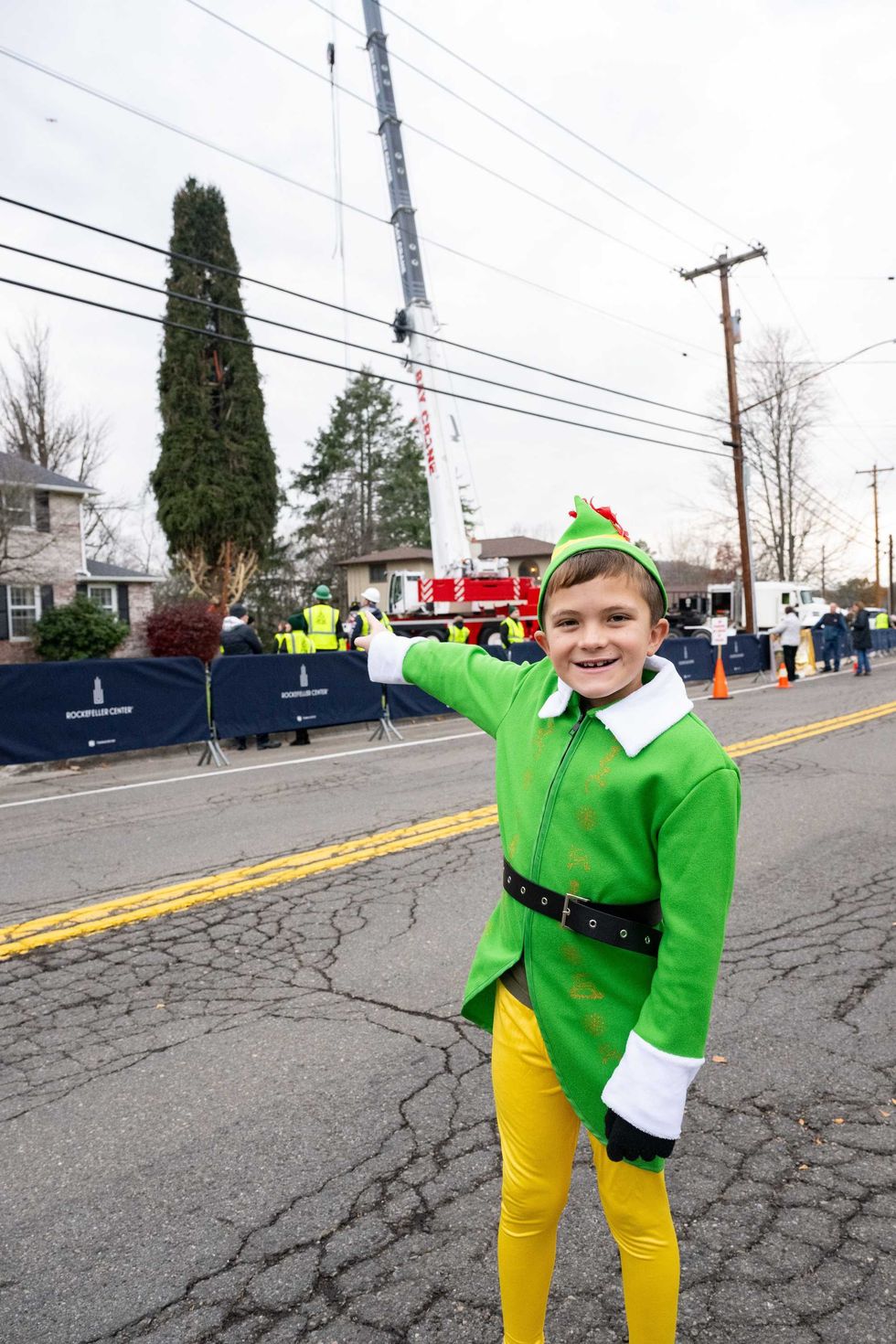 Noah McElligott, 10, poses near the wrapped 80-foot tall Norway Spruce that will serve as this year
