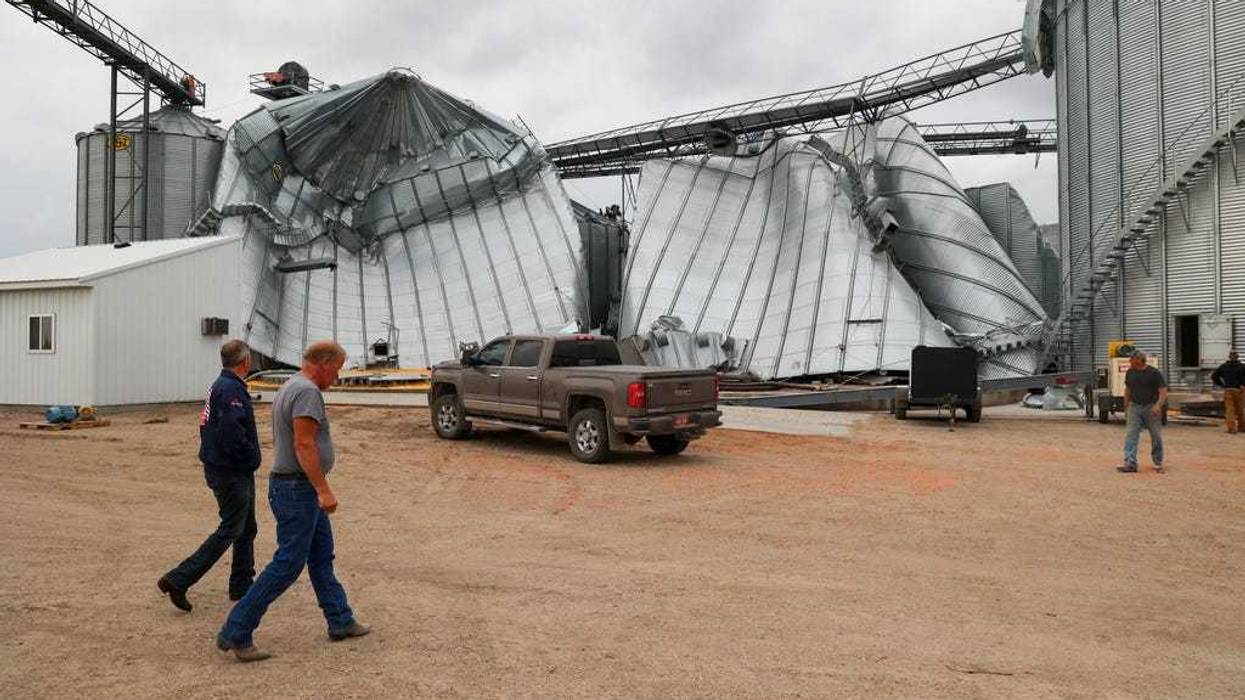 North Dakota Governor Kelly Armstrong walks by silos damaged by an EF5 tornado in Enderlin, N.D., on June 25, 2025.