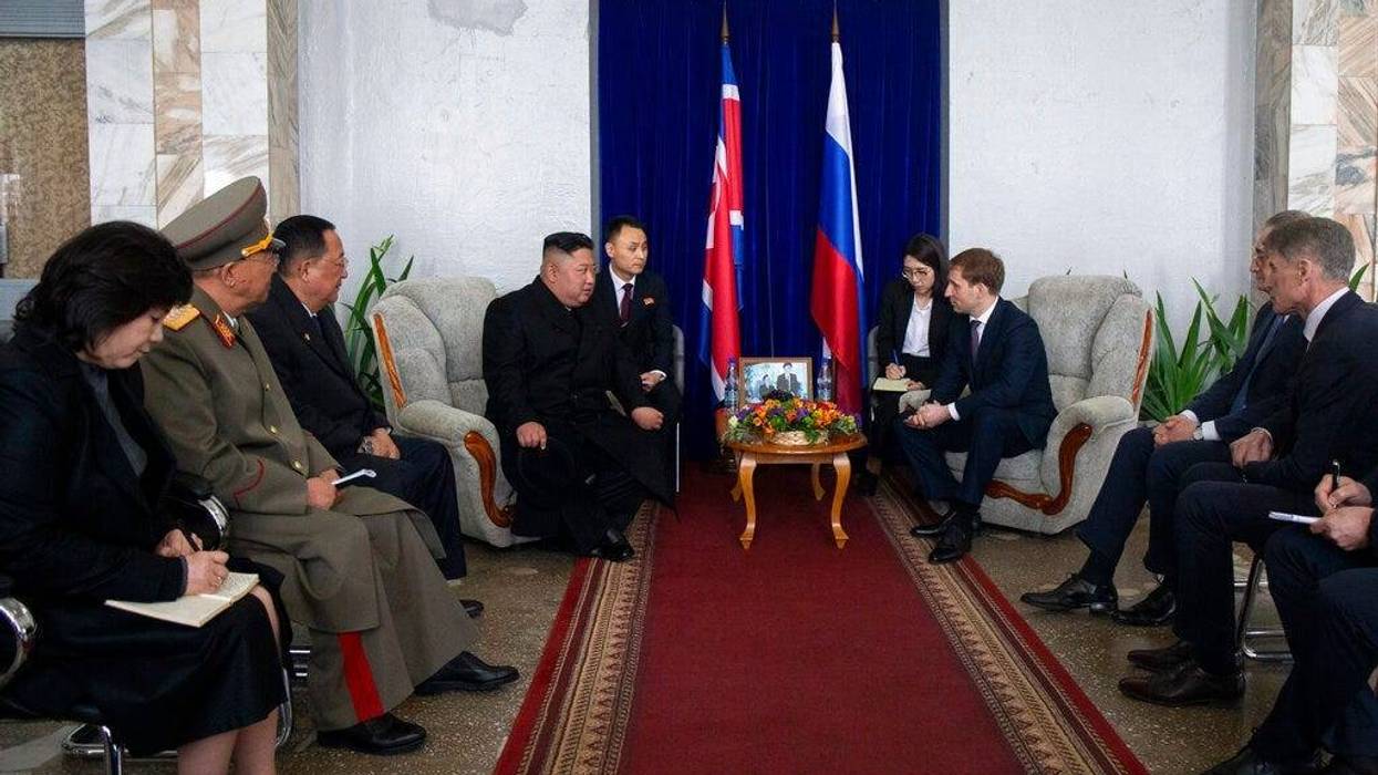 North Korea's leader Kim Jong Un, background, centre left, talks with Russian Minister for the development of the Russian Far East Alexander Kozlov