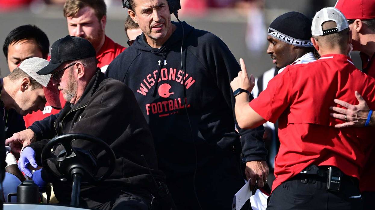 Nov 15, 2025; Bloomington, Indiana, USA; Wisconsin Badgers head coach Luke Fickell stands in the crowd surrounding an injured Wisconsin Badgers running back Gideon Ituka during the second half against the against the Indiana Hoosiers at Memorial Stadium. Mandatory Credit: Marc Lebryk-Imagn Images