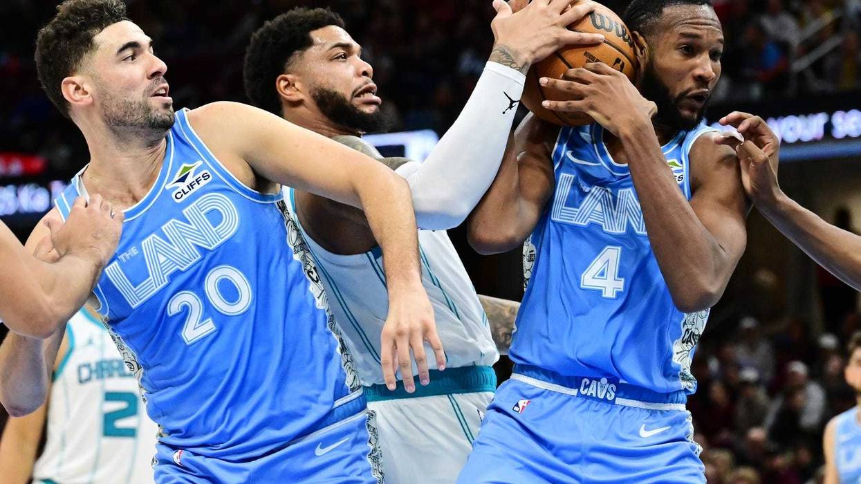 Nov 17, 2024; Cleveland, Ohio, USA; Charlotte Hornets forward Miles Bridges (0) and Cleveland Cavaliers forward Evan Mobley (4) go for a rebound as forward Georges Niang (20) looks on during the second half at Rocket Mortgage FieldHouse.