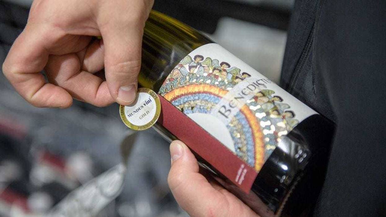 Nun Thekla of St. Hildegard Abbey labes wine bottels with an award label in the cellar on October 20, 2017 near Rudesheim on the Rhine, Germany.