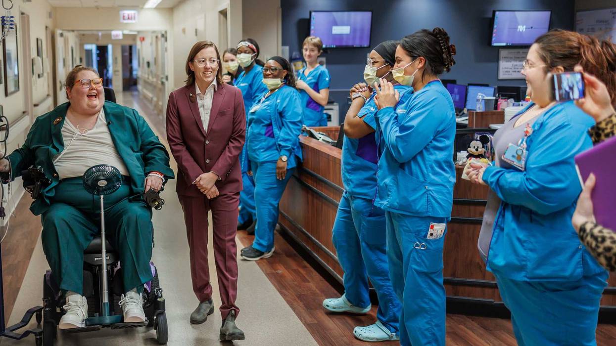 Nurses at Northwestern Hospital cheer on Annesley Clark and Christine Corso as they walk down the aisle for their wedding, which took place inside the hospital — one day before Clark was scheduled to have open heart surgery.