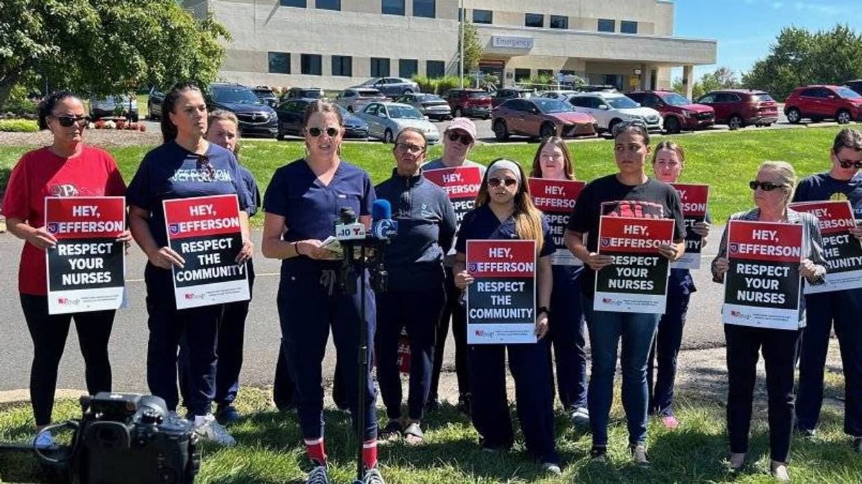 Nurses standing side by side, many holding signs saying "Hey Jefferson, respect your nurses"