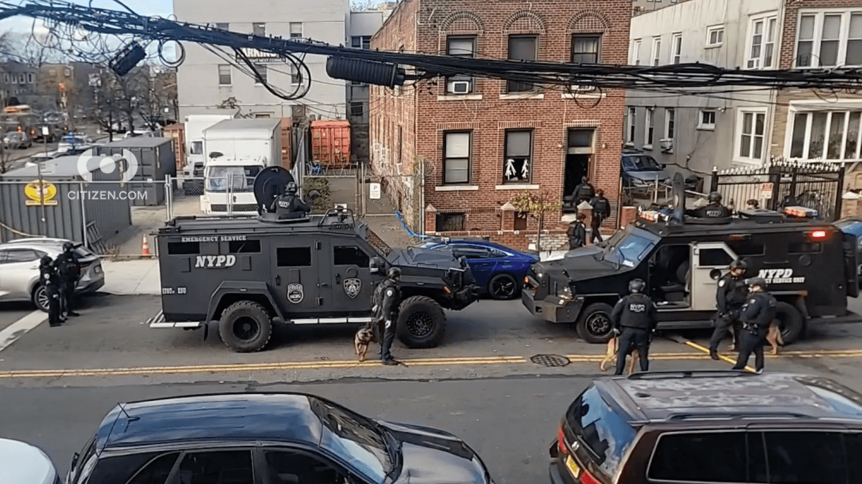 NYPD officers are seen outside of the home in Brownsville on Monday