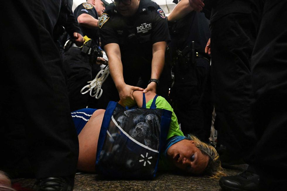 NYPD officers arrest protesters at the Lexington Ave/63rd Street subway station on May 6, 2023