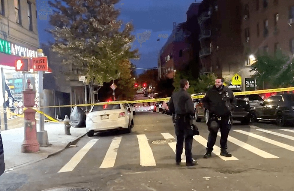NYPD officers cordon off a street near the shooting scene on Sunday evening