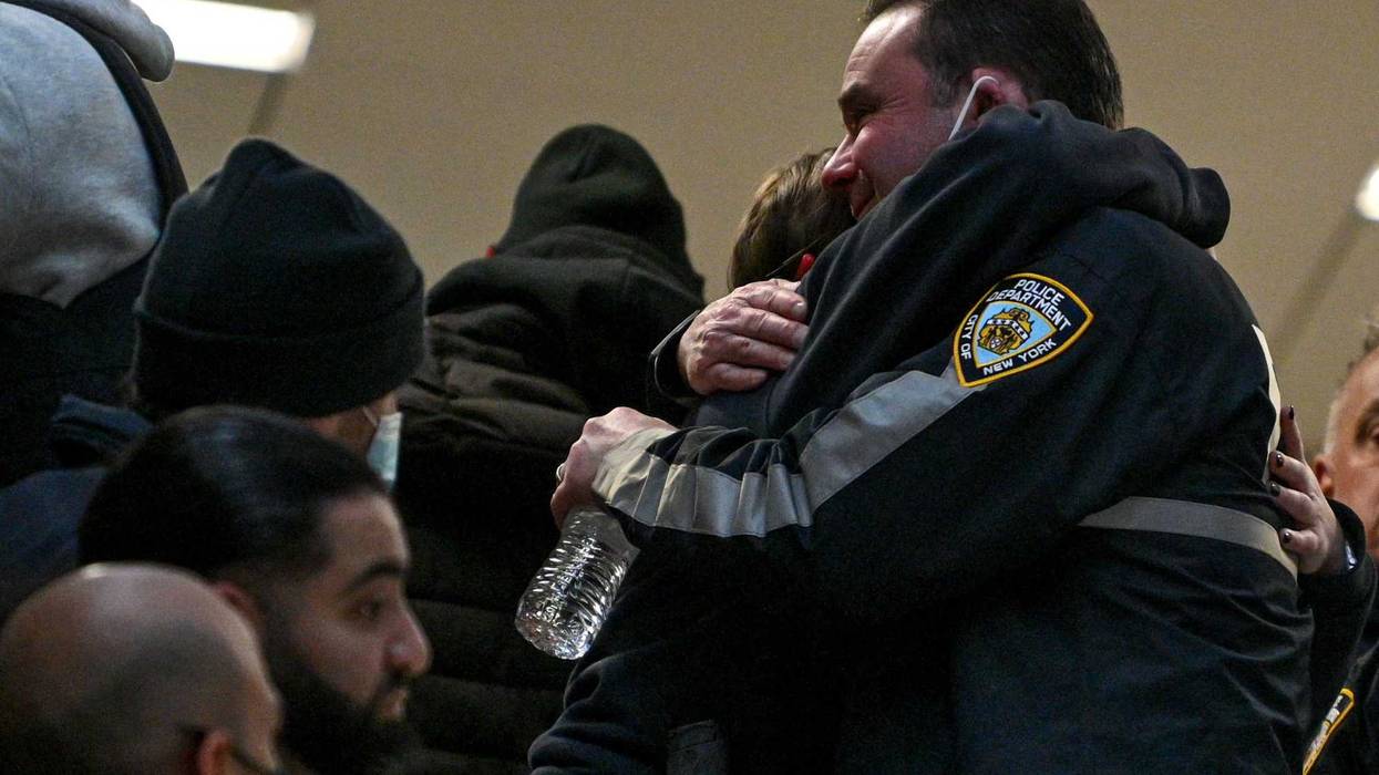 NYPD officers embrace at Harlem Hospital on January 21, 2022 in New York City. One officer was killed and the other remains in critical condition at Harlem Hospital.
