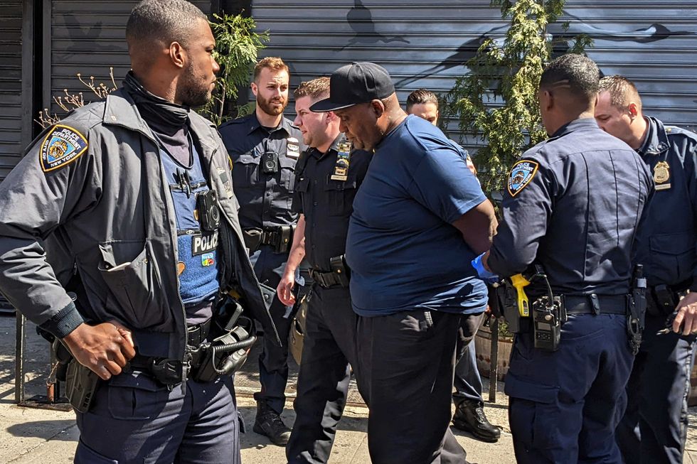 NYPD officers handcuff subway shooting suspect Frank R. James, 62, in the East Village section, of New York, Wednesday, April 13, 2022