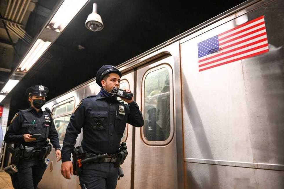 NYPD officers investigate an incident on an Uptown 4 subway after an emergency brake was pulled near Union Square on April 12, 2022