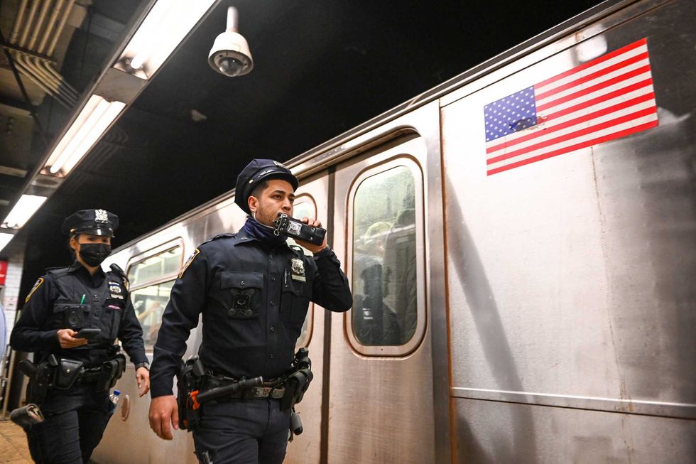 NYPD officers investigate an incident on an Uptown 4 subway train after an emergency brake was pulled near Union Square on April 12, 2022