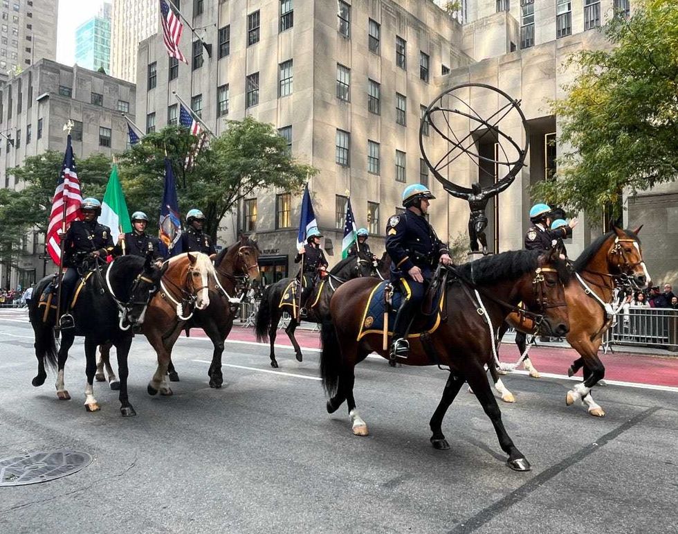 NYPD officers on horseback pass Rockefeller Center