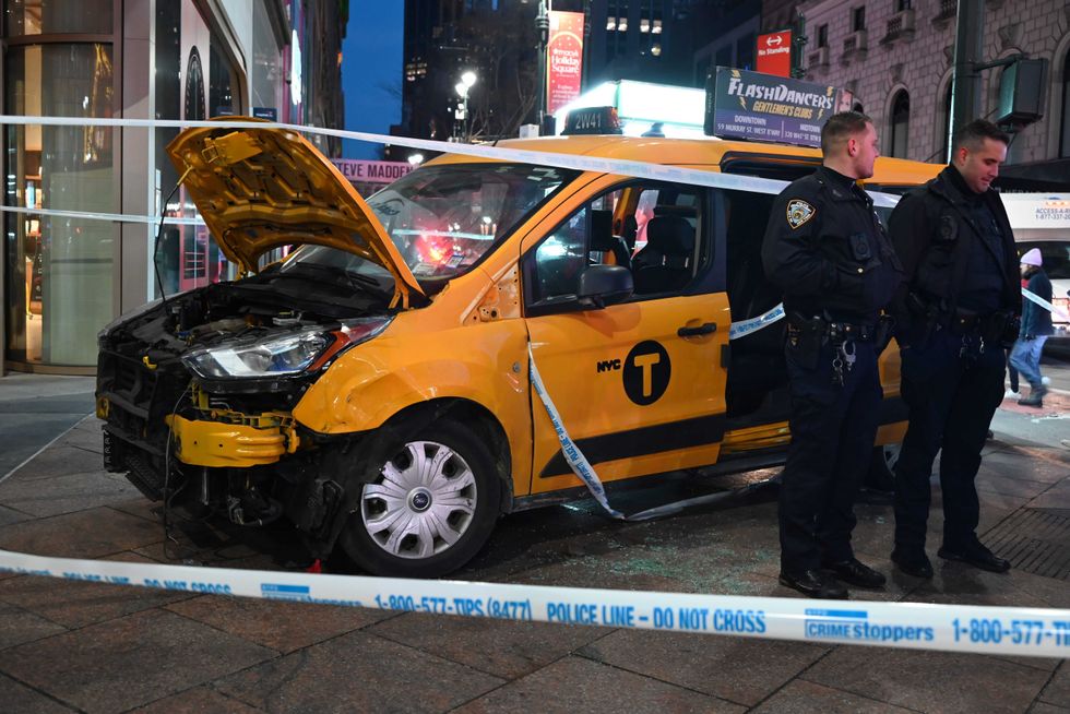 NYPD officers stand near the smashed taxi at Herald Square on Dec. 25, 2024