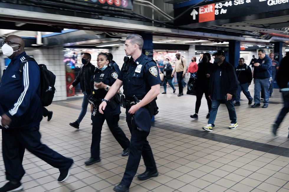 NYPD officers walk through the Port Authority subway station