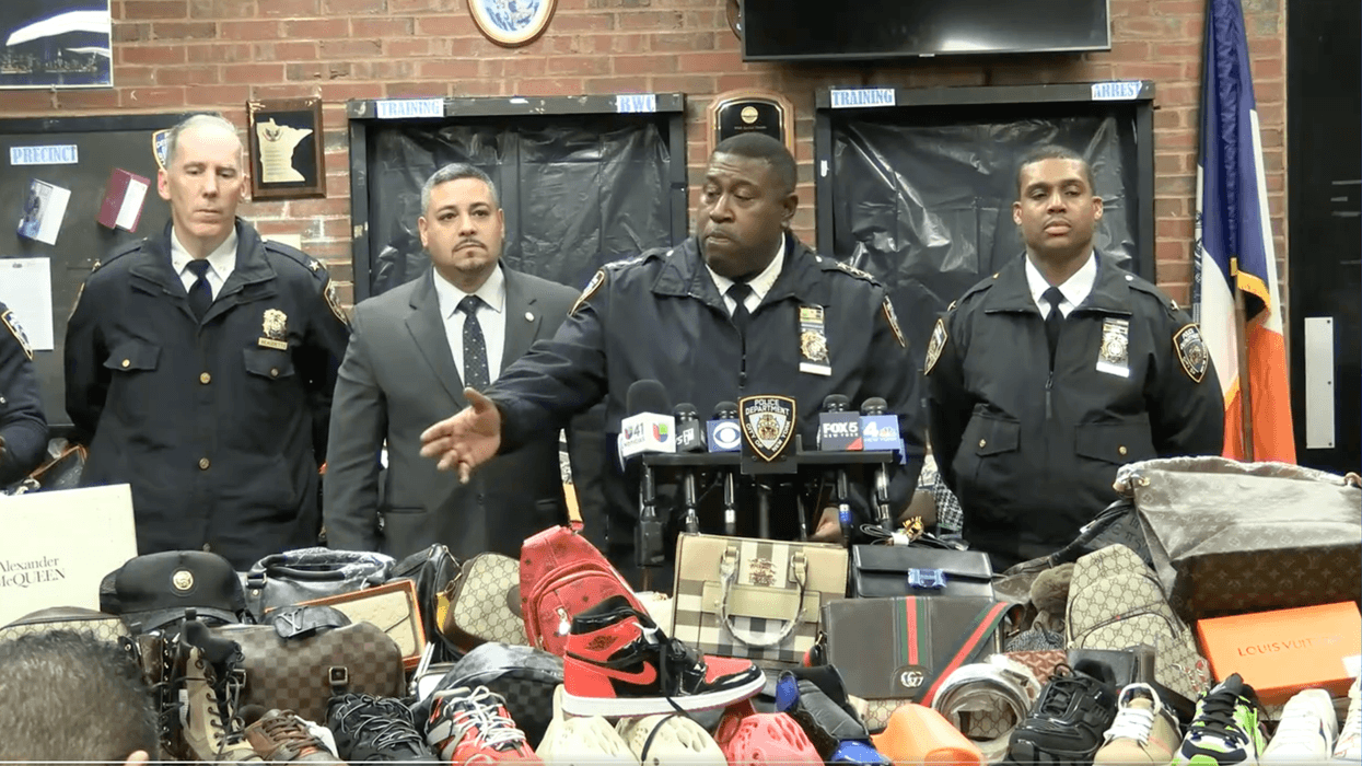 NYPD officials at conference with seized merchandise.