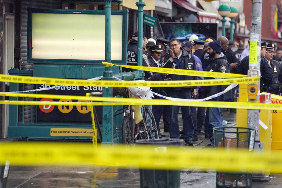 NYPD personnel gather at the entrance to a subway stop in the Brooklyn borough of New York, Tuesday, April 12, 2022