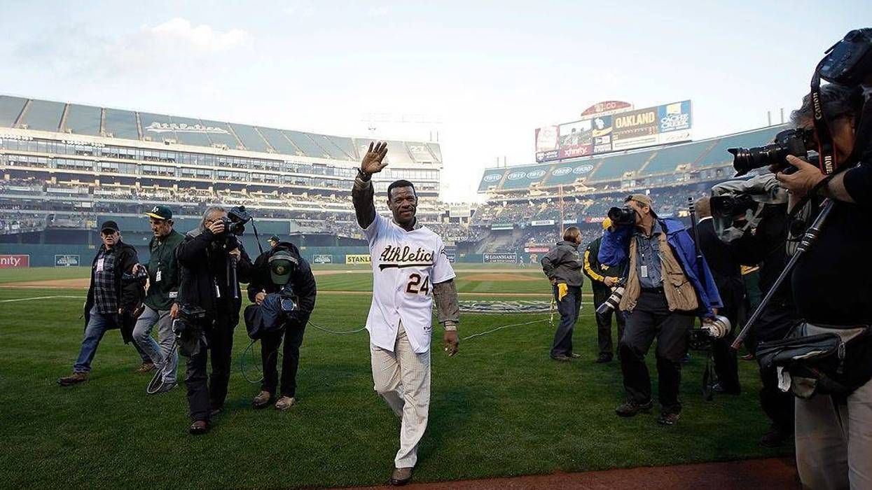 OAKLAND, CA - MARCH 31: Oakland Athletics great Rickey Henderson waves to the crowd after throwing out the ceremonial first pitch before the Oakland Athletics played against the Cleveland Indians on Opening Day at O.co Coliseum on March 31, 2014 in Oakland, California.