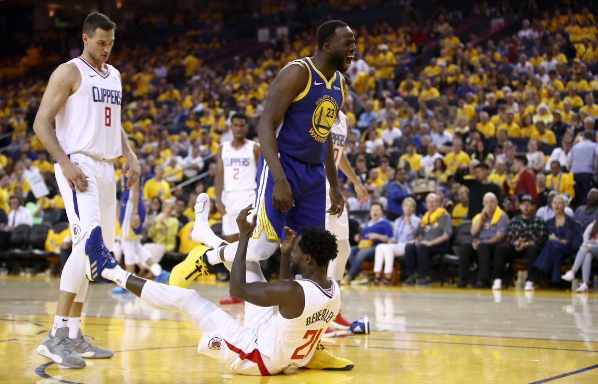 OAKLAND, CALIFORNIA - APRIL 24: Draymond Green #23 of the Golden State Warriors gets tangled wth Patrick Beverley #21 of the LA Clippers after Green was called for an offensive foul during Game Five of the first round of the 2019 NBA Western Conference Playoffs at ORACLE Arena on April 24, 2019 in Oakland, California