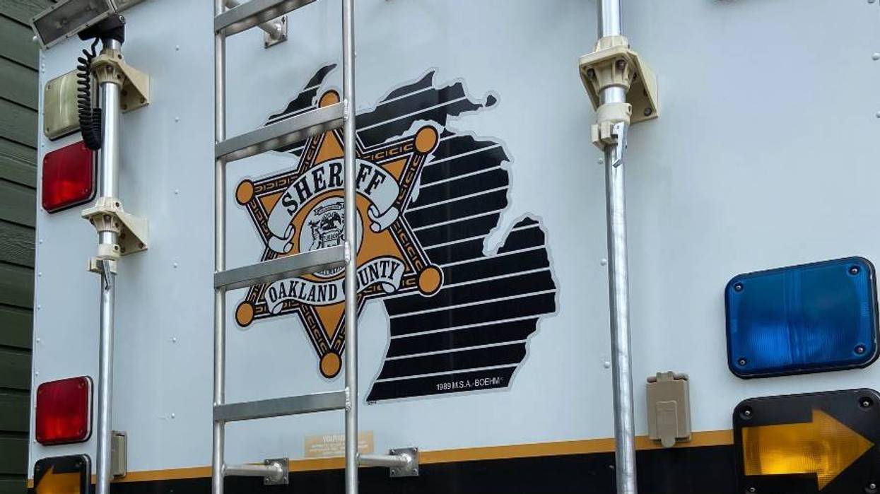 Oakland County Sheriff's vehicle side: badge, Michigan outline, ladder, and emergency lights.