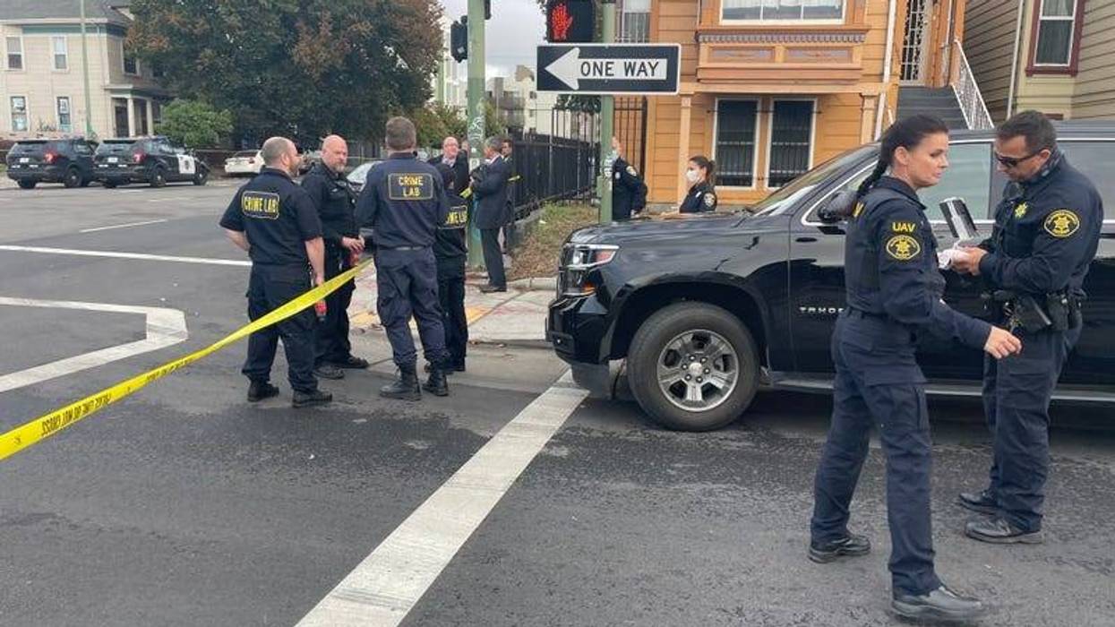 Oakland police officers block off gas station where a former officer was shot last month.