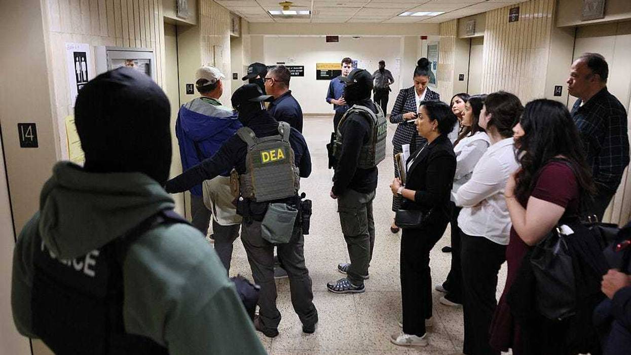 Observers watch as federal agents detain an individual in the halls of immigration court at the Jacob K. Javitz Federal Building on June 10, 2025 in New York City.