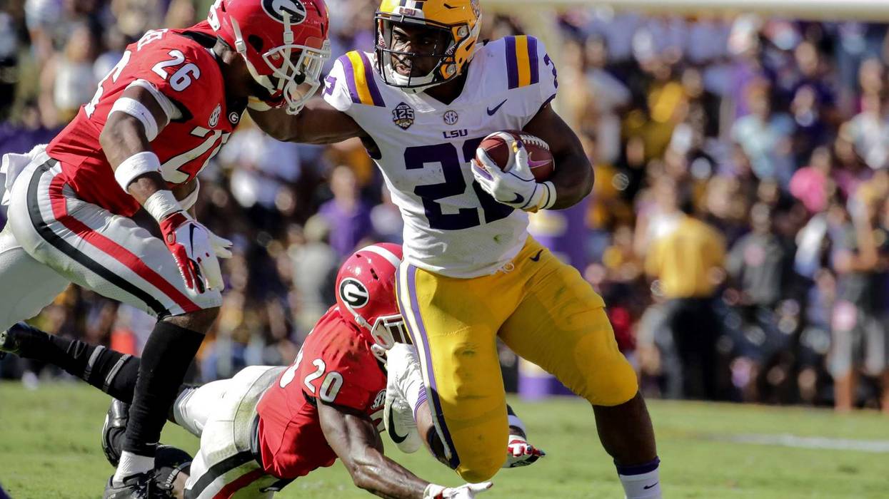 Oct 13, 2018; Baton Rouge, LA, USA; LSU Tigers running back Clyde Edwards-Helaire (22) break away from Georgia Bulldogs defensive back Tyrique McGhee (26) and defensive back J.R. Reed (20) during the second quarter at Tiger Stadium. Mandatory Credit: Deri