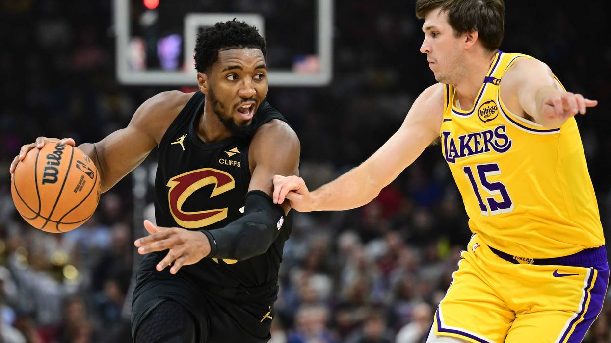 Oct 30, 2024; Cleveland, Ohio, USA; Cleveland Cavaliers guard Donovan Mitchell (45) drives to the basket against Los Angeles Lakers guard Austin Reaves (15) during the first quarter at Rocket Mortgage FieldHouse.
