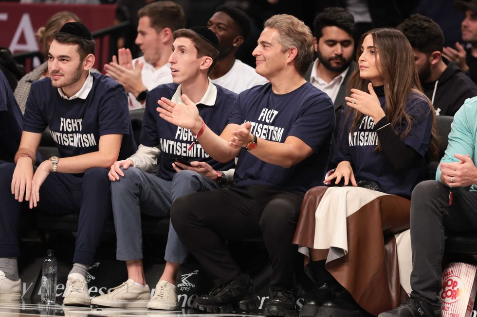 Oct 31, 2022; Brooklyn, New York, USA; Fans wearing shirts with the phrase fight antisemitism react during the first half of the game between the Brooklyn Nets and the Indiana Pacers at Barclays Center.