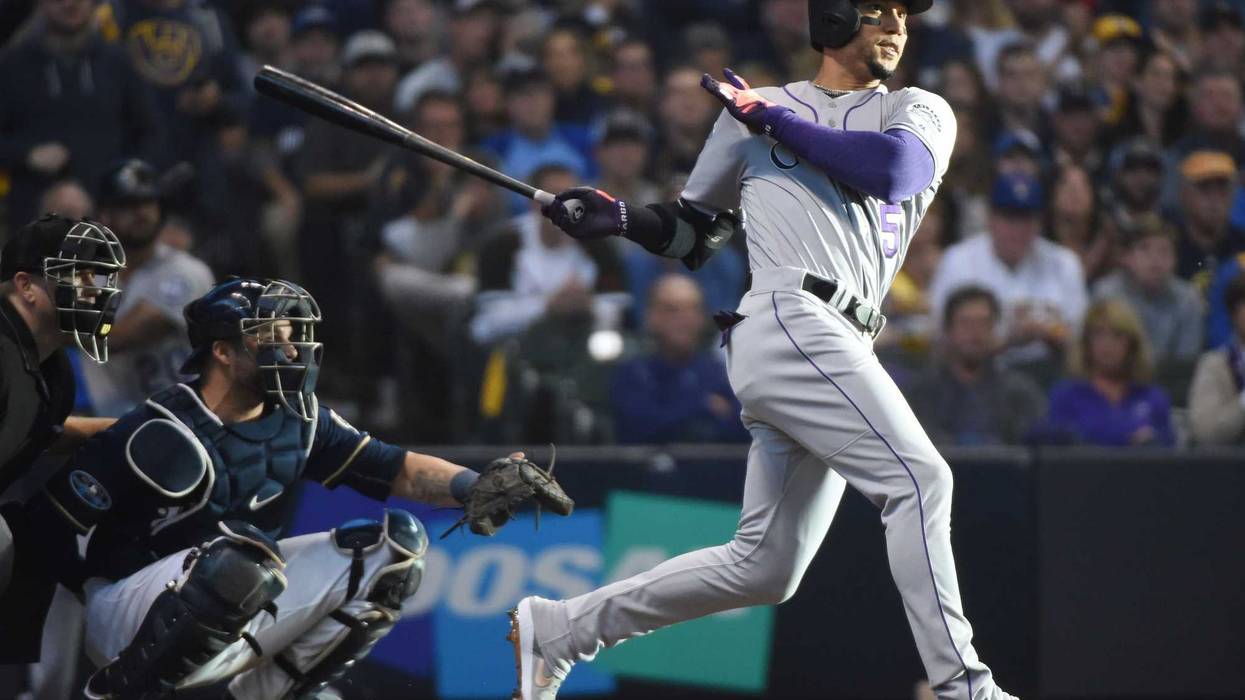 Oct 4, 2018; Milwaukee, WI, USA; Colorado Rockies outfielder Carlos Gonzalez hits a triple in the fifth inning against the Milwaukee Brewers in game one of the 2018 NLDS playoff baseball series at Miller Park. Mandatory Credit: Benny Sieu-USA TODAY Sports