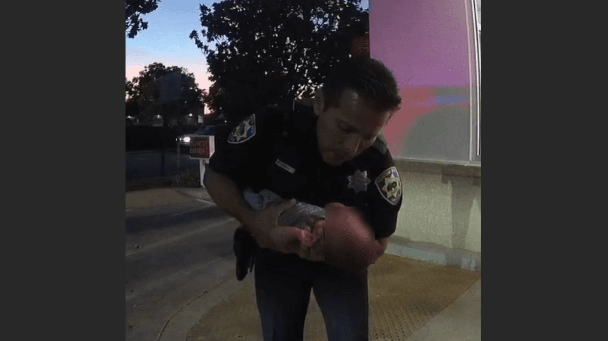 Officer Garcia performing CPR on a baby boy outside In-N-Out Burger.