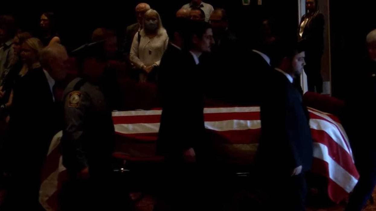 Officer Trey Sutton's casket is escorted out of Victory Tabernacle Church in Midlothian.