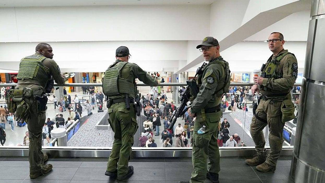 Officers look on as travelers stand in long lines at Atlanta Hartsfield-Jackson International Airport