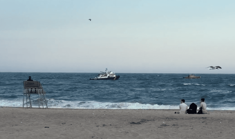 Official sea vessels searching for two missing teen swimmers at Jacob Riis Park in Queens on Friday.