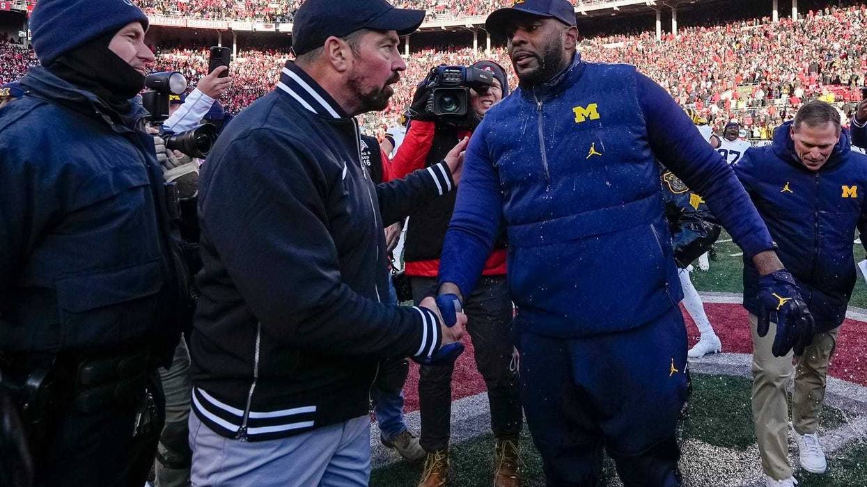 Ohio State Buckeyes head coach Ryan Day shakes hands with Michigan Wolverines head coach Sherrone Moore following Michigan's 13-10 victory.