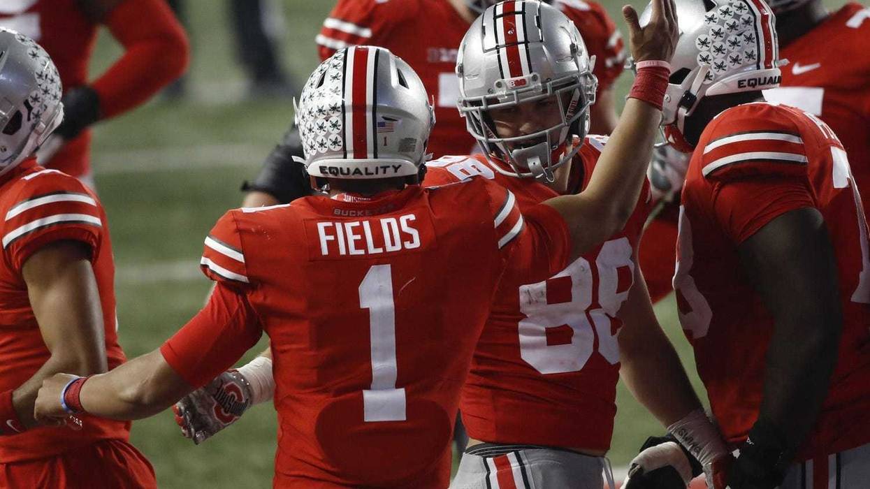 Ohio State Buckeyes quarterback Justin Fields high fives tight end Jeremy Ruckert after the pair connected for a 7-yard touchdown during the third quarter of the NCAA football game against the Rutgers Scarlet Knights at Ohio Stadium.