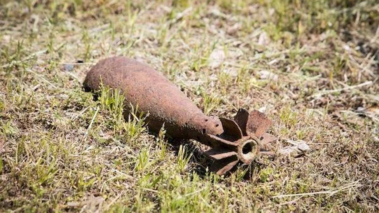 Old rusty artillery grenade shell lying on the ground
