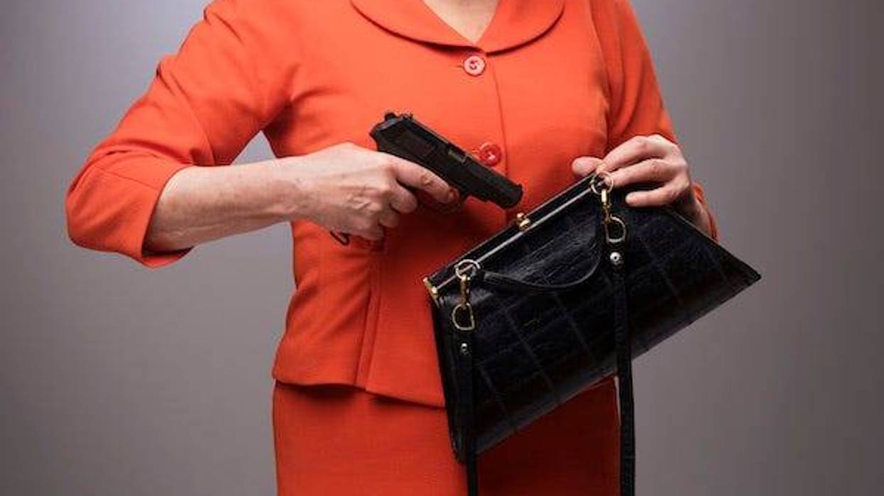Old woman pulling a gun out of her handbag