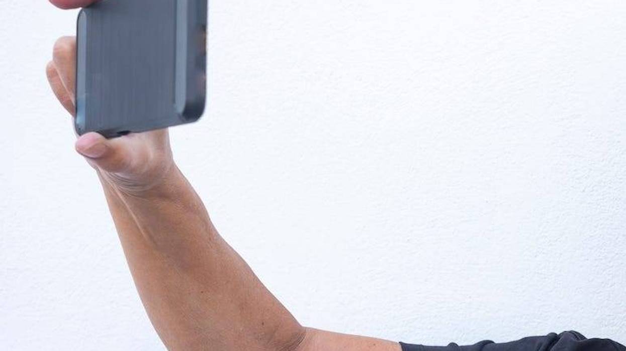 Older woman taking picture with phone